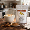 Addictive Wellness Cistanche pouch beside a chai latte and a dish of cistanche powder