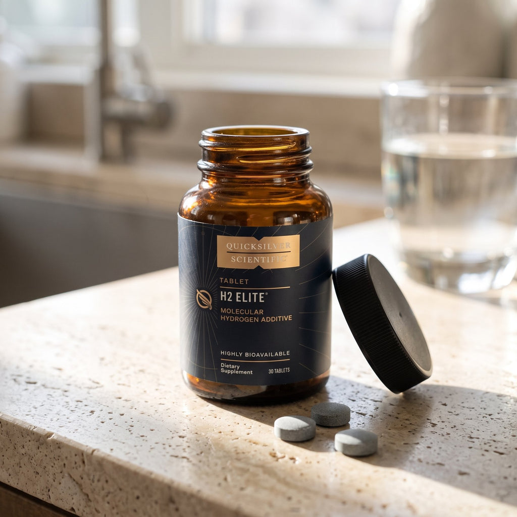 Open jar of H2 Elite with three small gray tablets on a stone counter