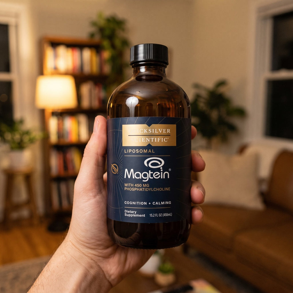 Hand holding a bottle of Quicksilver Liposomal Magtein in a cozy living room